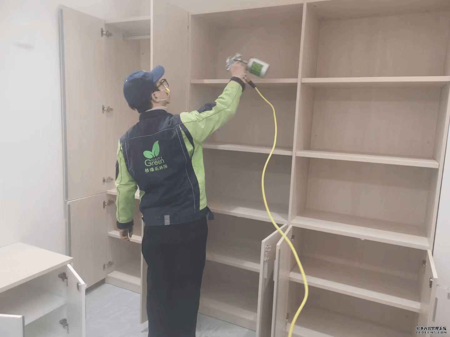 地下室施工时，施工人员相互配合，对大型储物架进行全面除醛作业，一人负责高处喷涂，另一人在下方协助移动梯子、传递工具，确保储物架每一层都能得到有效治理，两人工作有条不紊。